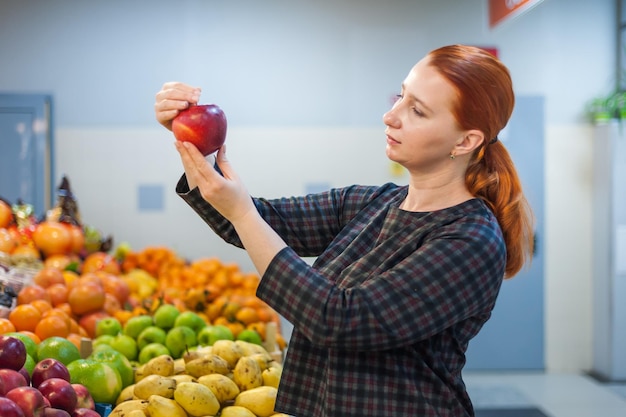 Garota caucasiana comprando produtos alimentares de legumes frescos no marketxA