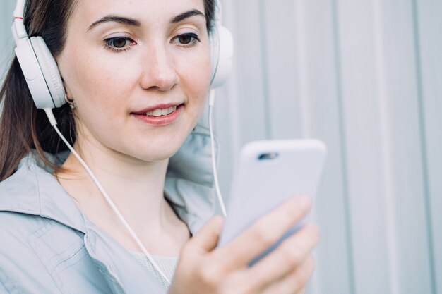 Garota caucasiana em fones de ouvido ouve uma mensagem de áudio