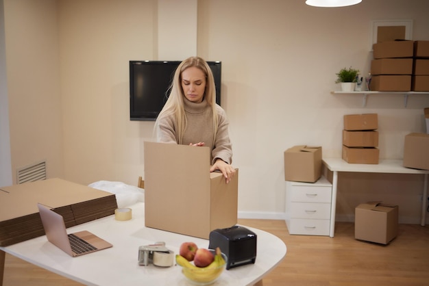 Garota caucasiana gravando caixas para se mudar para um novo apartamento