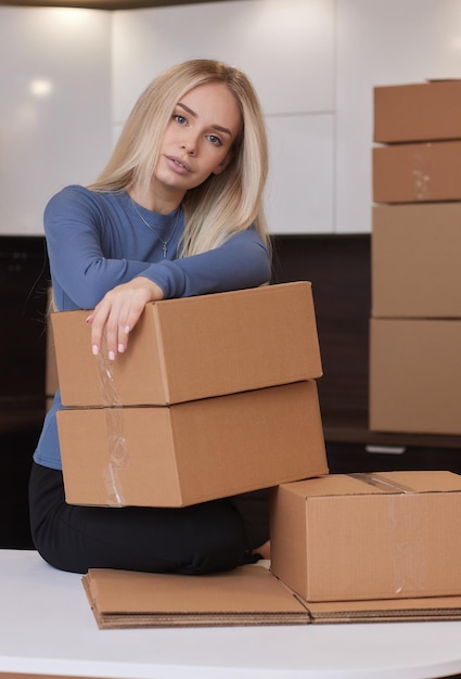 Garota caucasiana gravando caixas para se mudar para um novo apartamento
