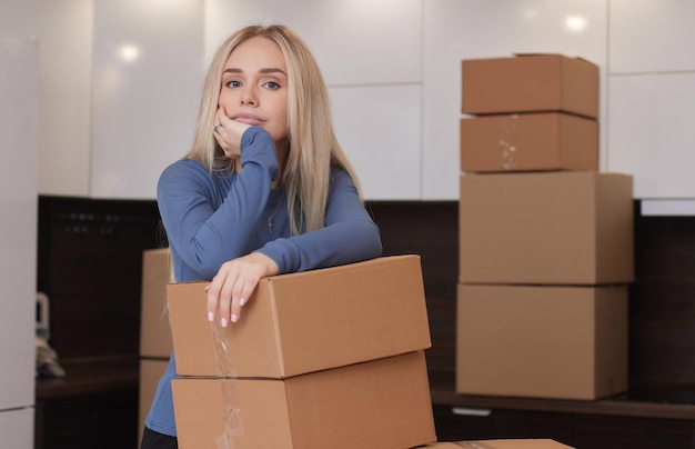 Garota caucasiana gravando caixas para se mudar para um novo apartamento