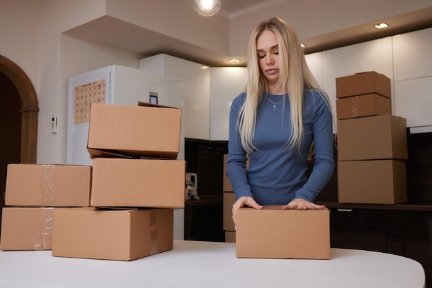 Garota caucasiana gravando caixas para se mudar para um novo apartamento