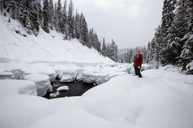 Garota caucasiana loira está curtindo o cenário de inverno canadense durante um dia de neve