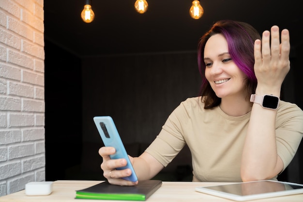 Garota com cabelo brilhante olha para a comunicação do ambiente doméstico do telefone à distância