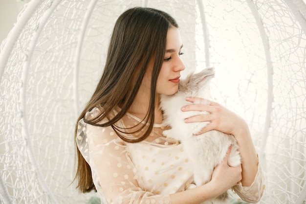 Garota com cabelo comprido. coelho branco nos braços da menina.