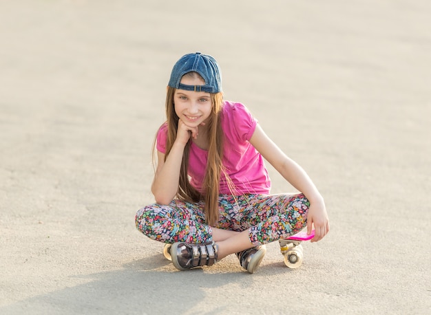 Garota com cabelo comprido, sentado no skate