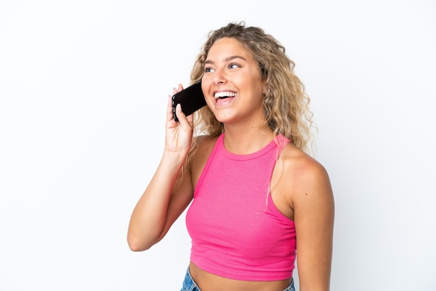 Garota com cabelo encaracolado, isolada no fundo branco, mantendo uma conversa com o celular