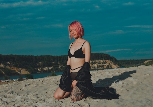 Foto garota com cabelo rosa em um maiô contra o céu