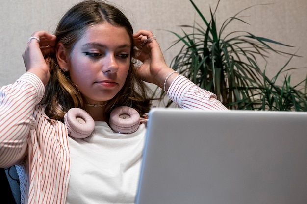 Garota com fones de ouvido está usando um laptop Assistir a filmes Chamada de vídeo
