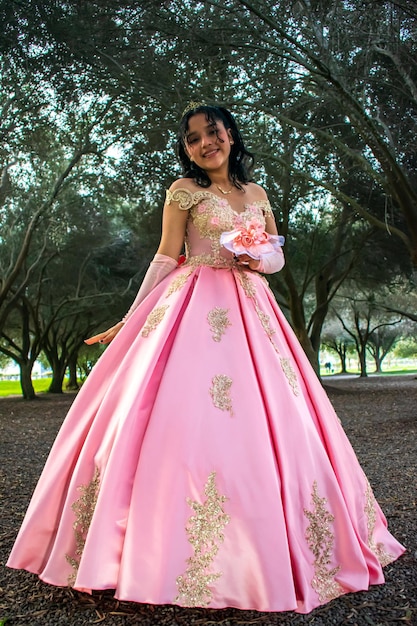 Garota com maquiagem e penteado em um vestido de princesa no meio de um parque e árvores verdes