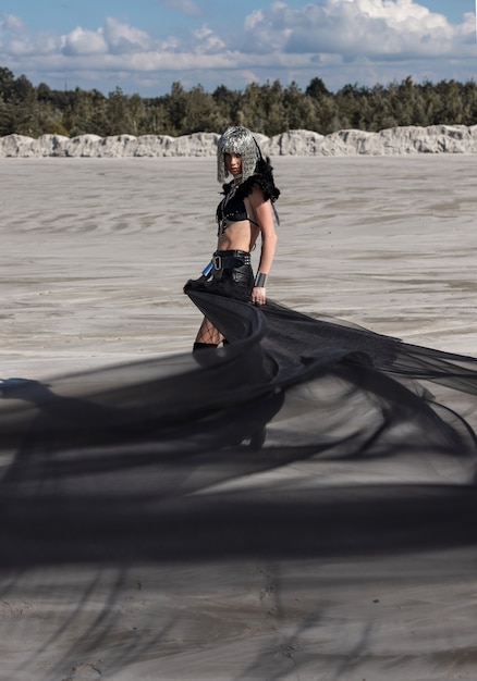 Garota com roupa de festival criativo posando no deserto