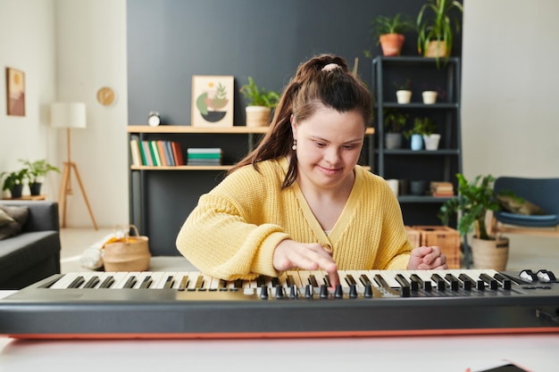 Garota com Síndrome de Down tocando sintetizador