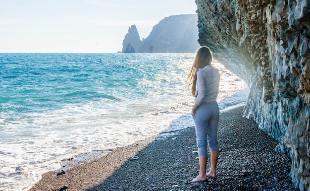 Garota com um agasalho cinza na praia