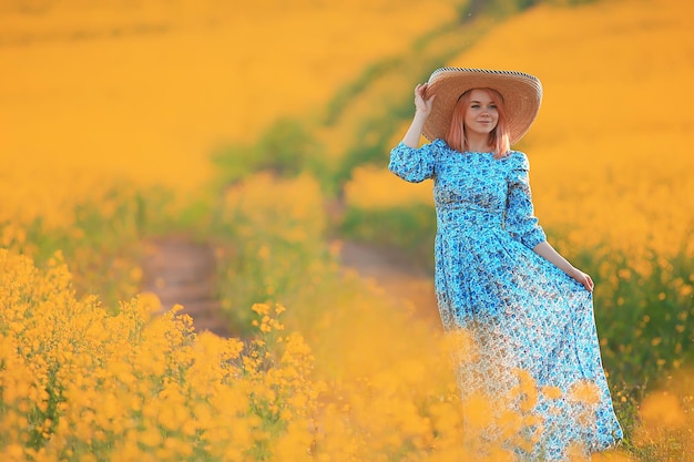 Garota com um chapéu de vestido longo vintage em um campo de flores, feliz verão ensolarado liberdade feminina