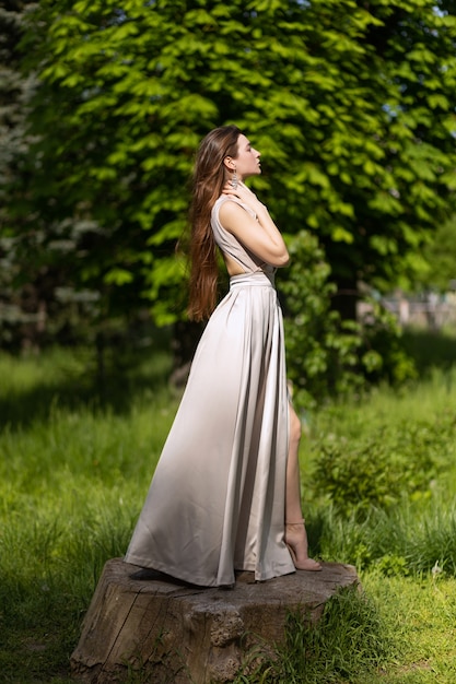 Garota com um vestido longo da moda posando na rua