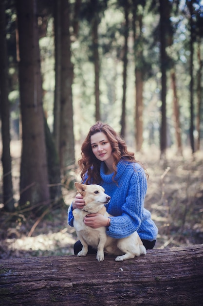 Garota com uma camisola sentado com um cachorro