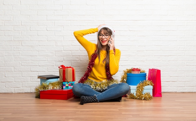 Garota comemorando as férias de natal, mantendo uma conversa com o celular com alguém