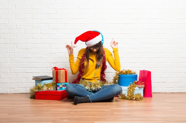 Garota comemorando as férias de Natal ouvindo música com fones de ouvido e dançando