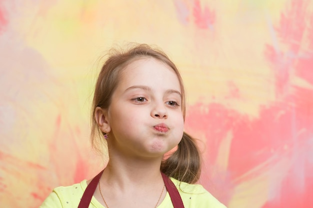 Garota comendo com a boca cheia de comida na parede colorida abstrata Desfrute do conceito de cozinha deliciosa Comida e dieta saudáveis Criança e infância