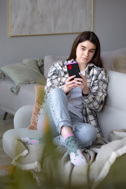 Garota concentrada fazendo videochamada no telefone usando câmera frontal para se comunicar