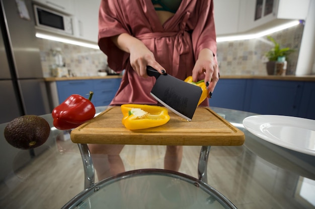 Garota cortando legumes na cozinha