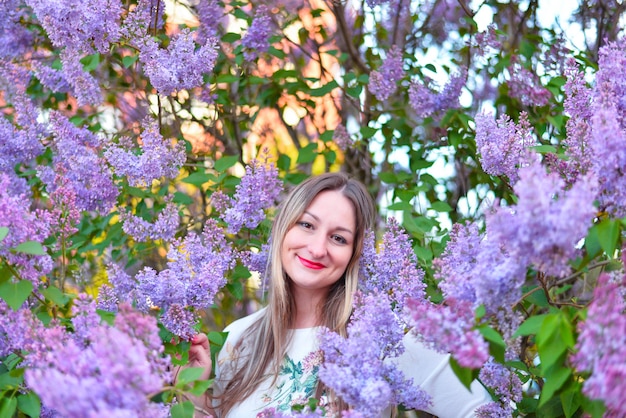 garota curtindo a temporada romântica tranquila posando perto de lilases