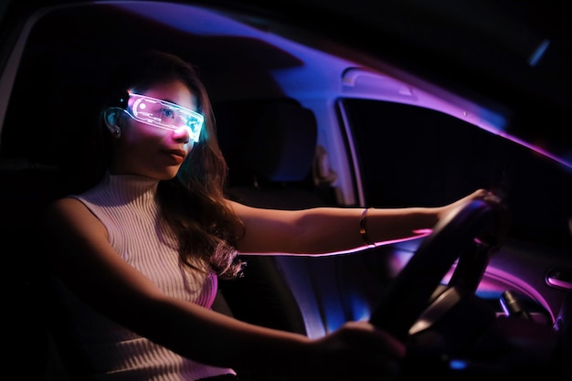 Foto garota cyberpunk fashion dirige uma mulher asiática supercarro com futuros óculos digitais