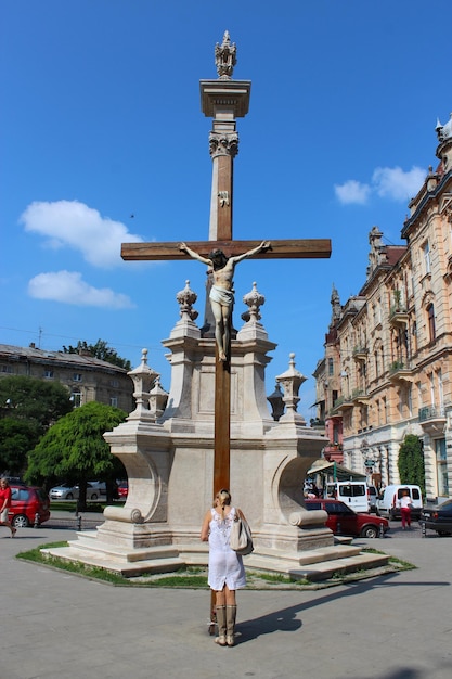 Garota da cidade rezando perto dos croos em lugar religioso em Lvov