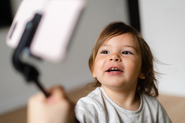 Garota da criança usando telefone com selfie pau para ligar para os avós