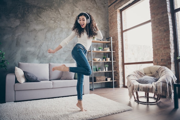 garota dançando ouvindo música se divertindo na sala de estar interior de estilo industrial moderno loft