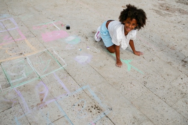 Foto garota de alto ângulo desenhando na calçada