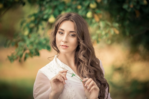 Garota de cabelo comprido em um vestido velho no jardim