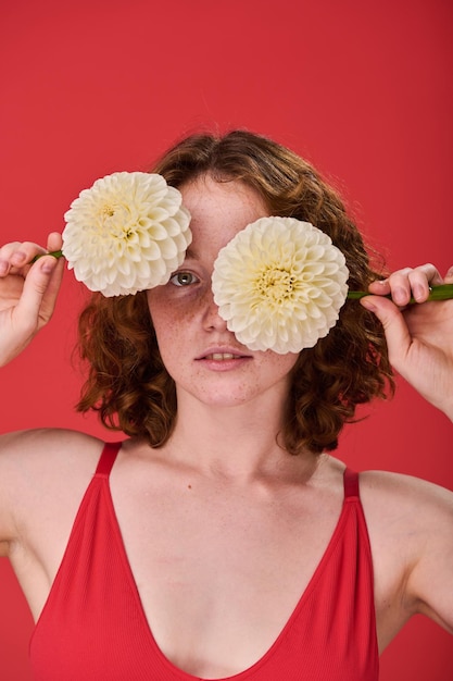 Garota de cabelo vermelho posando com flores