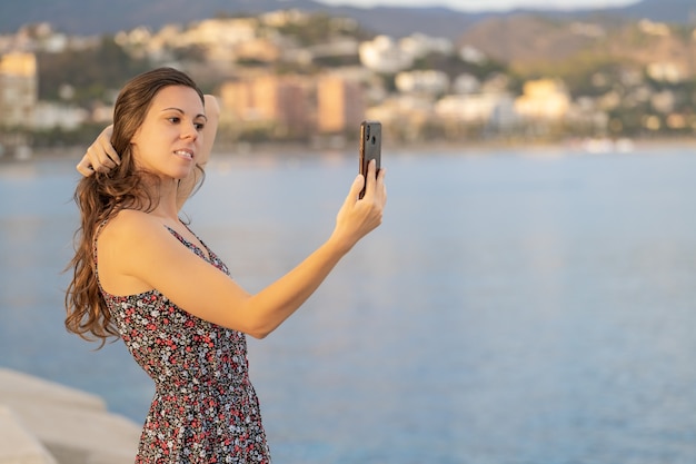 Garota de cabelos compridos se corrige se olhando na tela do celular