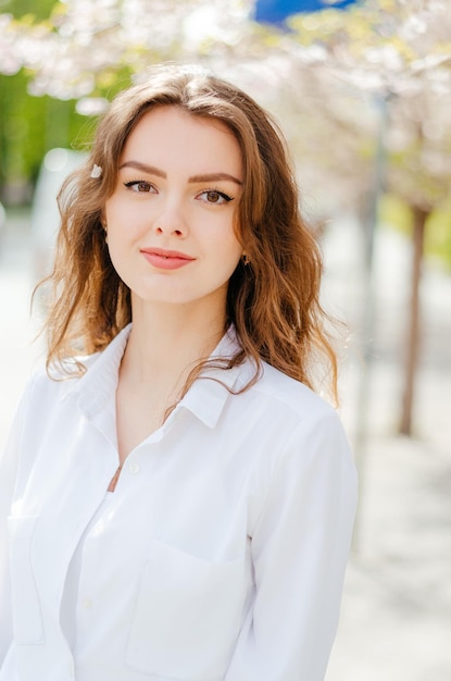 Garota de camisa branca perto das árvores de sakura Sakura floresce