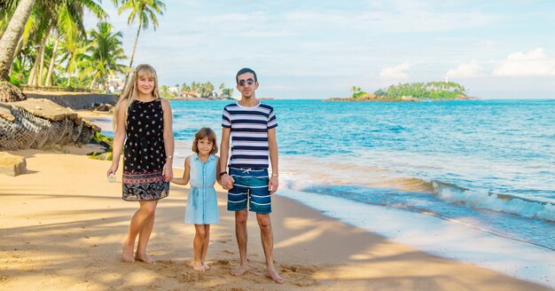 Garota de criança na praia com os pais