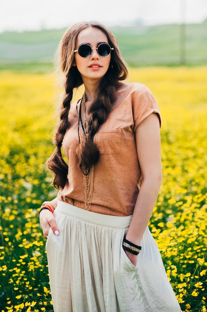 Garota de hippie romântica em pé em um campo. Verão. Estilo hippie.