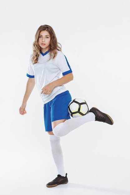 Garota de jogador de futebol europeu com uma bola de futebol contra um fundo branco
