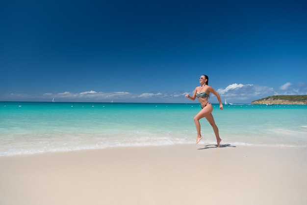 Garota de maiô sexy correndo na praia