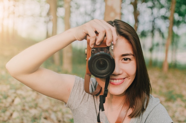 Garota de mulher de fotógrafo está segurando a câmera dslr