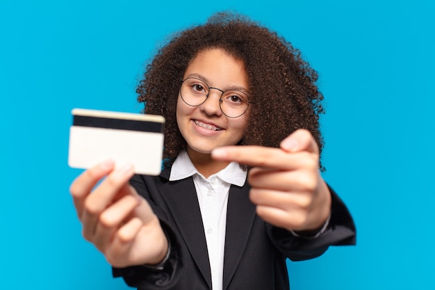 Garota de negócios de adolescente muito afro com um cartão de crédito. conceito de compras online