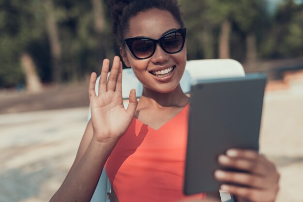 Garota de óculos de sol é chamada de vídeo no tablet pc