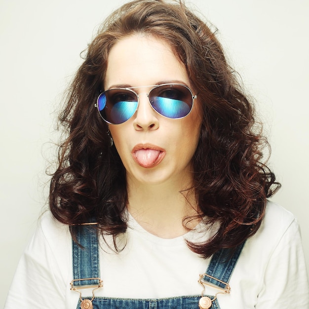 Garota de óculos de sol mostrando a língua
