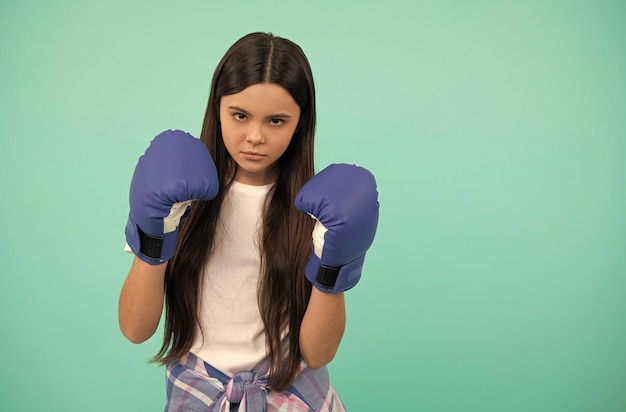 Garota de poder e autoridade sempre pronta em roupas esportivas luvas de boxe desafio esportivo perfurando