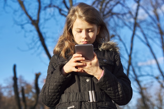 Garota de retrato ao ar livre com smartphone, garota da temporada de primavera com jaqueta