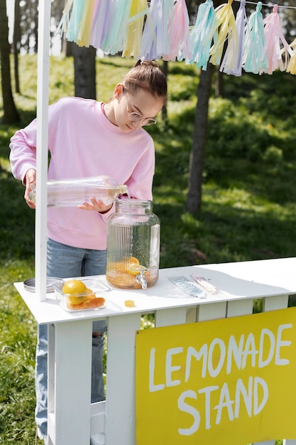 Foto garota de tiro completo fazendo limonada lá fora