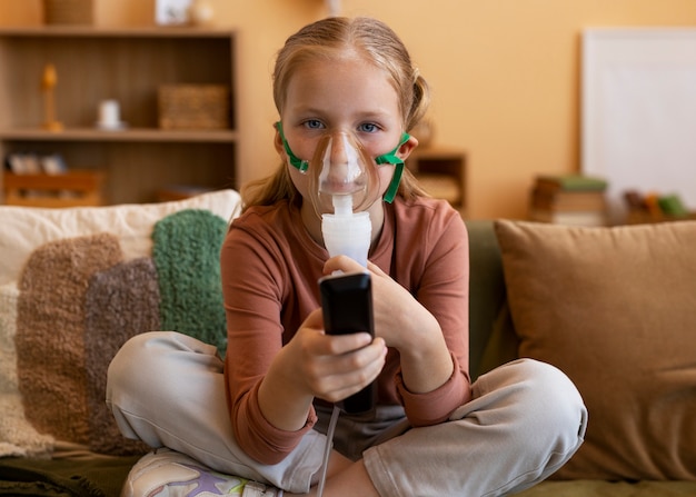 Foto garota de tiro completo usando nebulizador