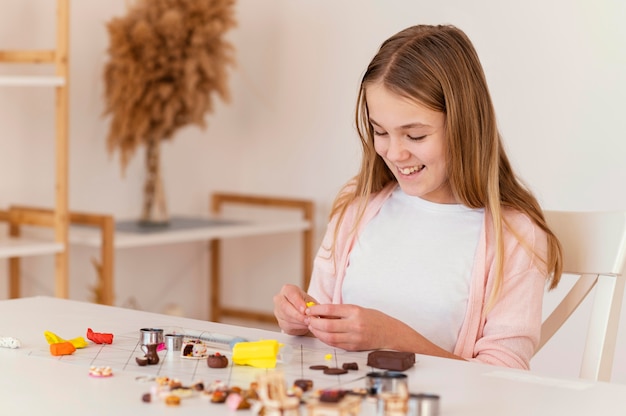 Foto garota de tiro médio brincando com argila