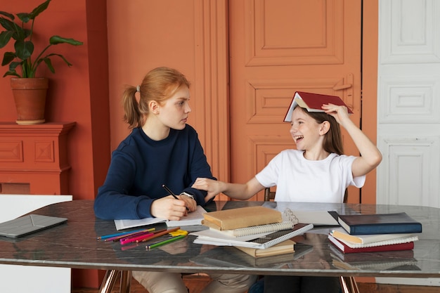 Foto garota de tiro médio colocando livro na cabeça