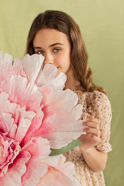 Foto garota de tiro médio segurando uma flor